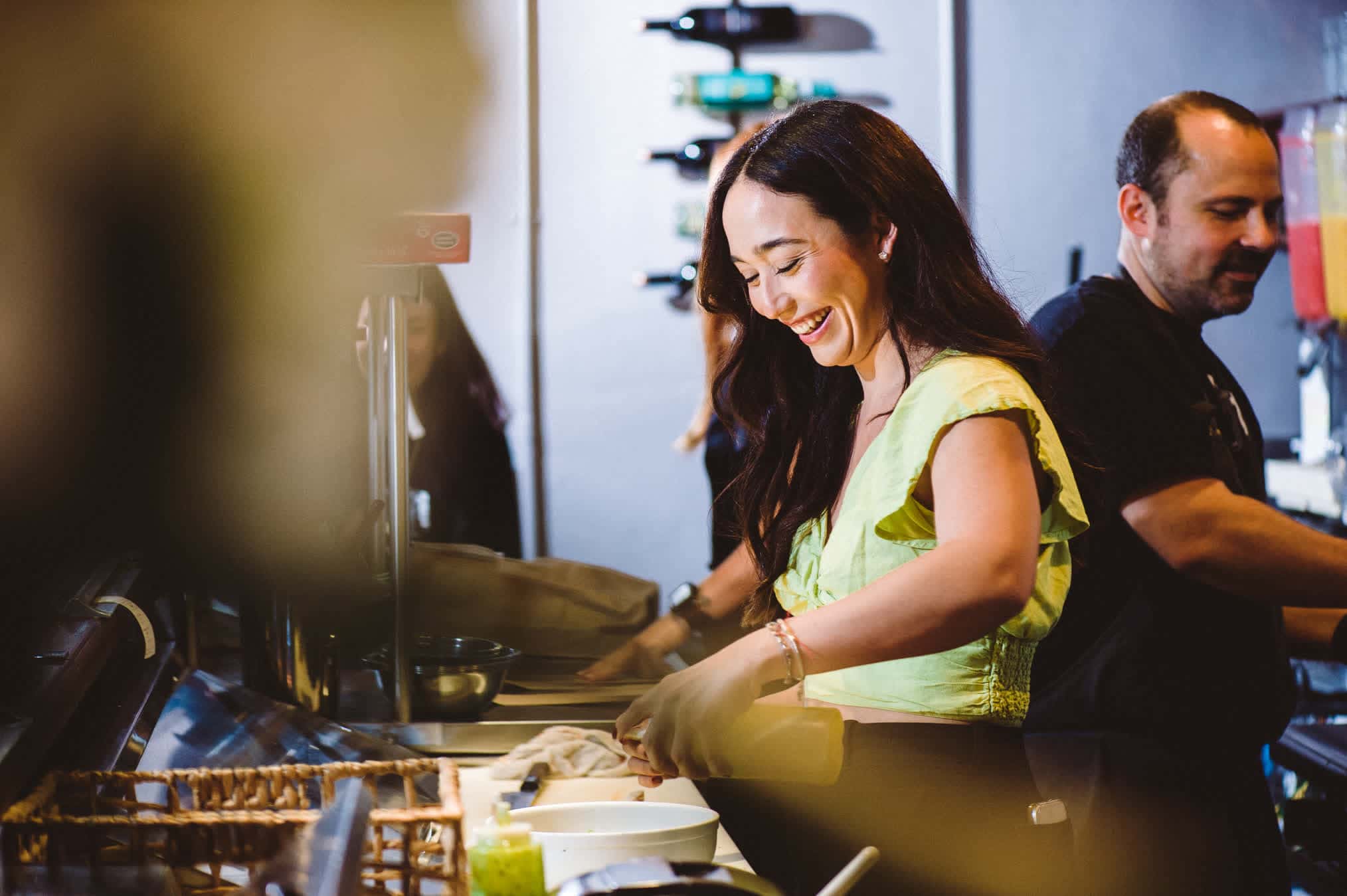 Sachi assembling food in her restaurant while smiling