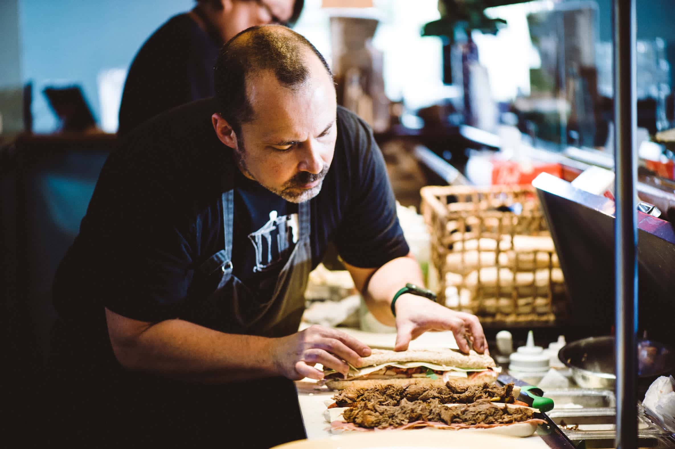 a person assembling a sandwich