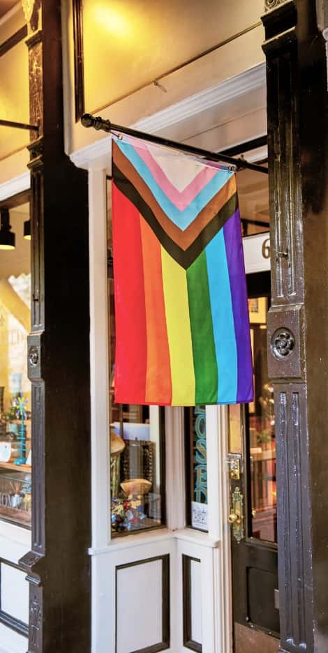 A Progress Pride flag hangs outside a storefront in Eureka Springs.