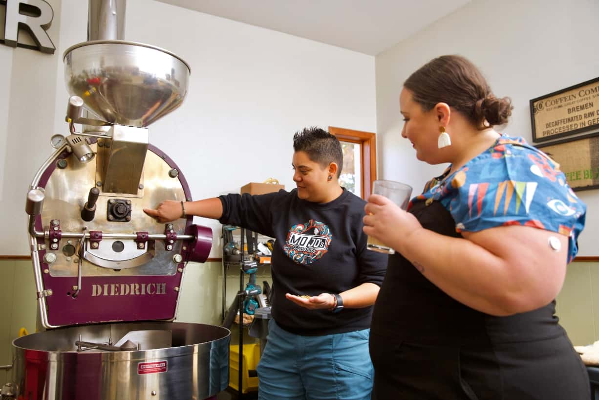 Belén shows Alysse how coffee beans are roasted.