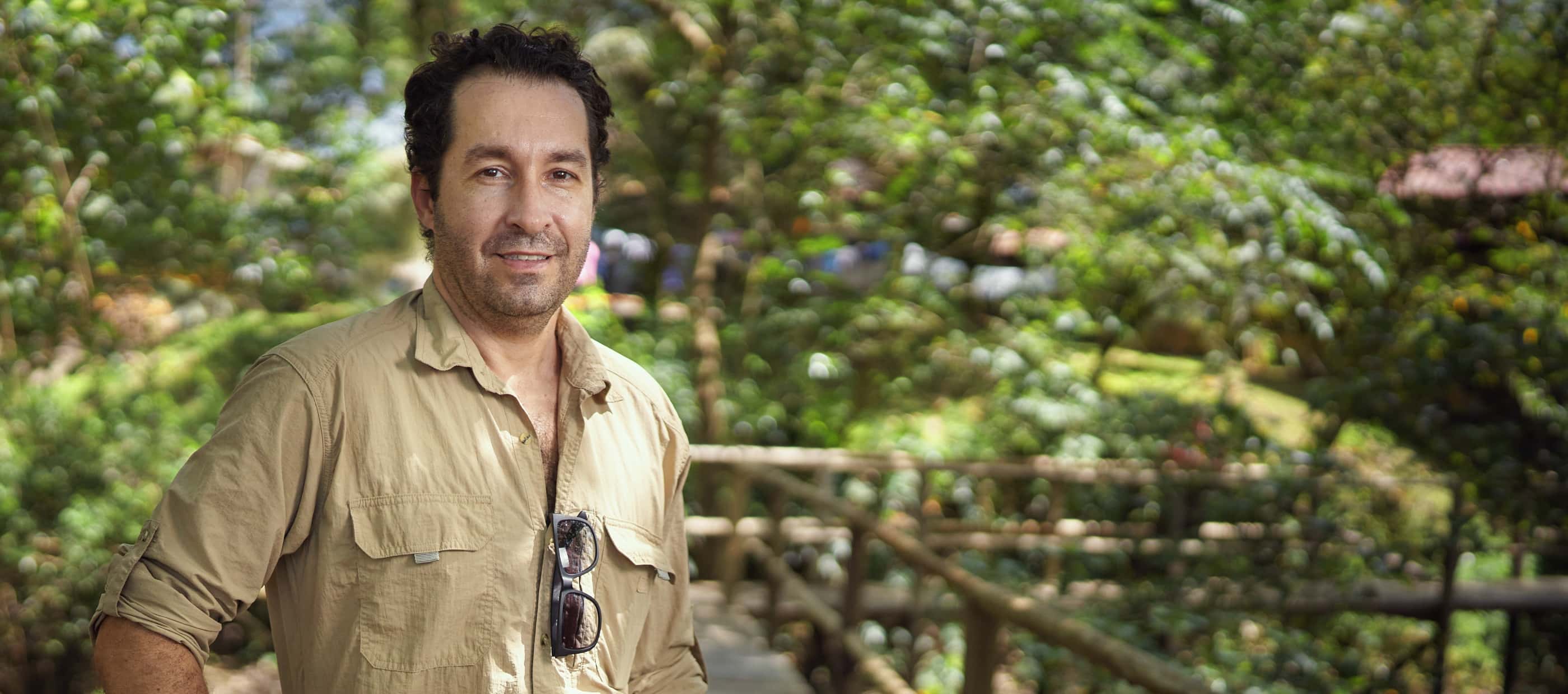 National Geographic Explorer Angelo Bernardino faces the camera, with the mangrove forest of Curuça, at the mouth of the Amazon River, behind him.