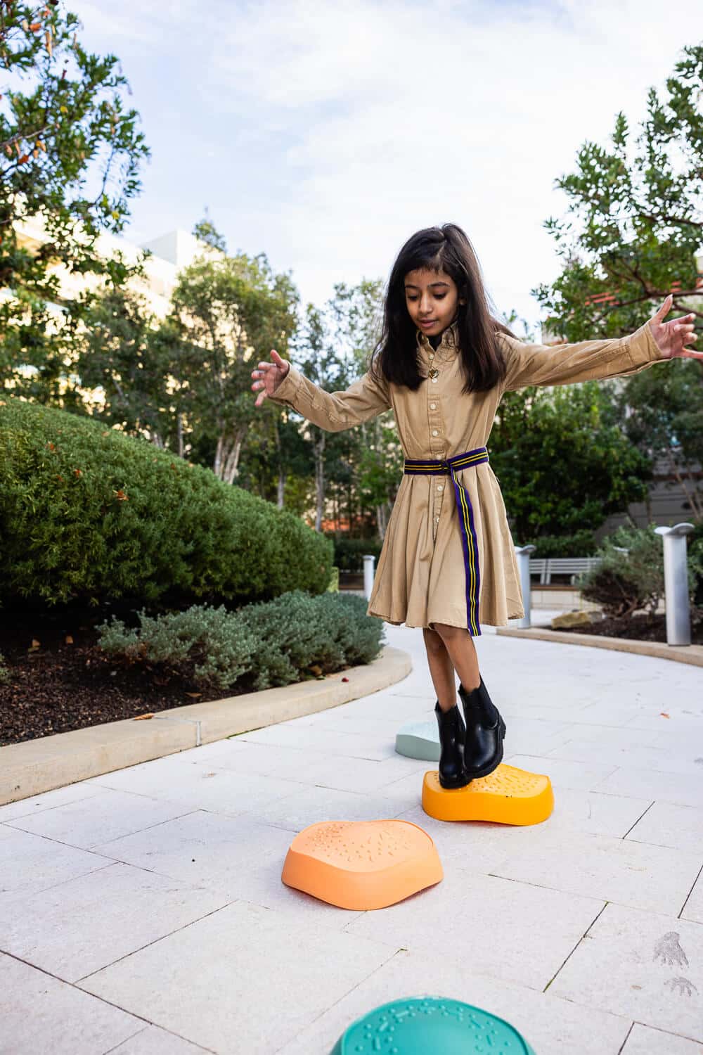 Leen stepping on colorful rocks, vertical