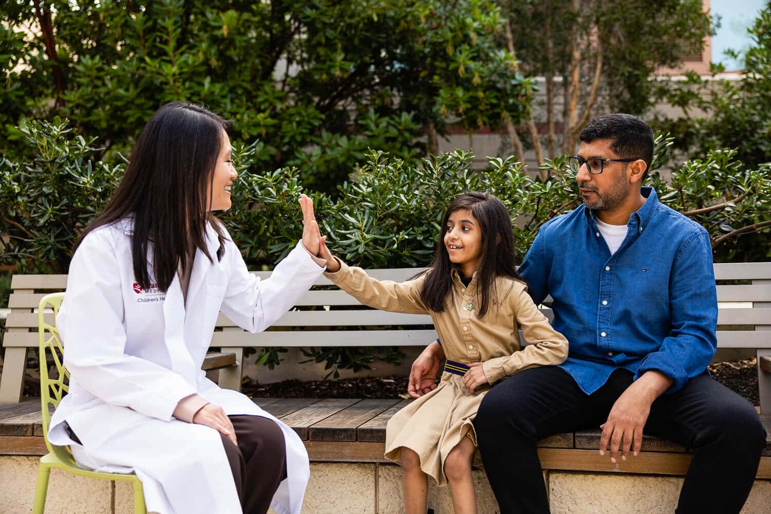 Dr. Si high-fives Leen, Mohammed on bench