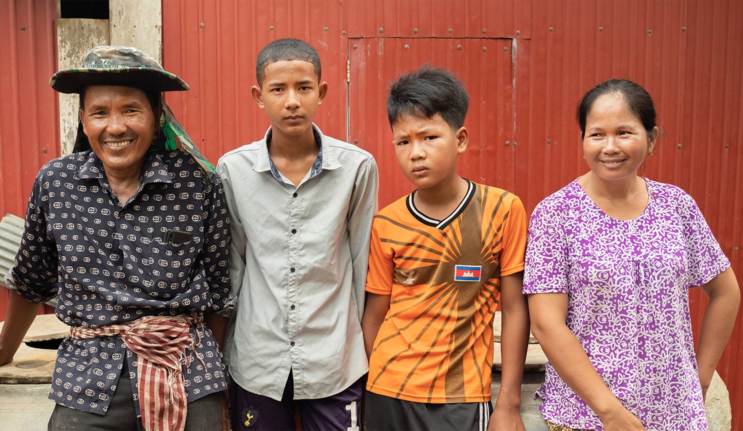 Cheang Sophat, left, and wife Hem Champa, far right, were able to send their second child to college after earning more money from vegetables grown in a nethouse. The couple is confident they will be able to send their third child, 14-year-old Phat Daroth, second from right, to college as well. Photo credit: Max Fannin for UC Davis 