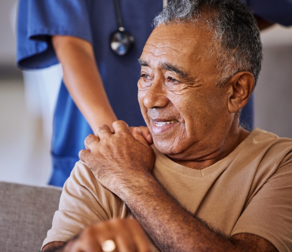 An older man is being helped by a nurse.