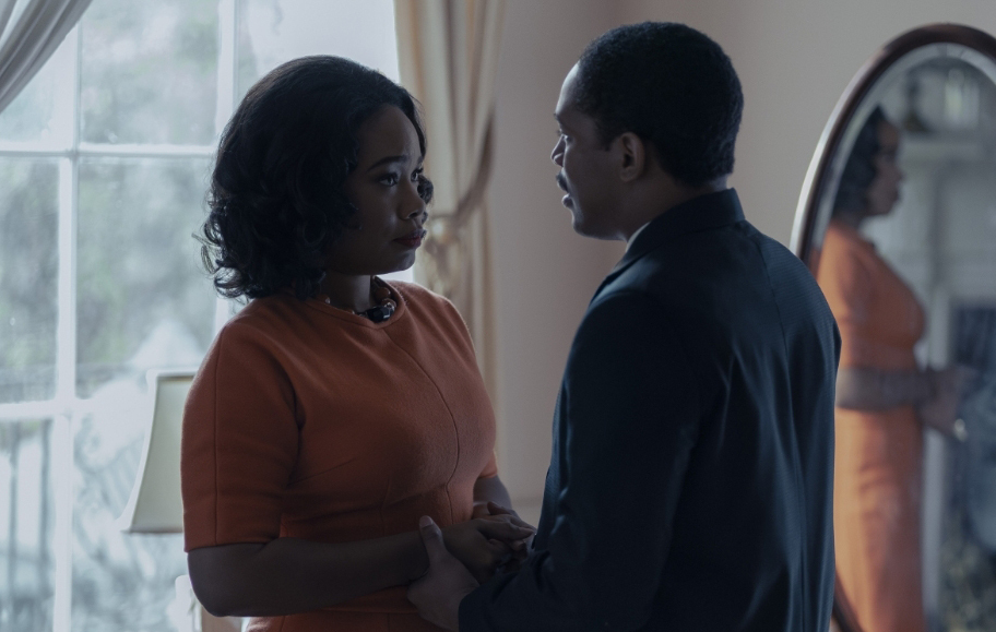 A man and woman standing in front of a mirror.