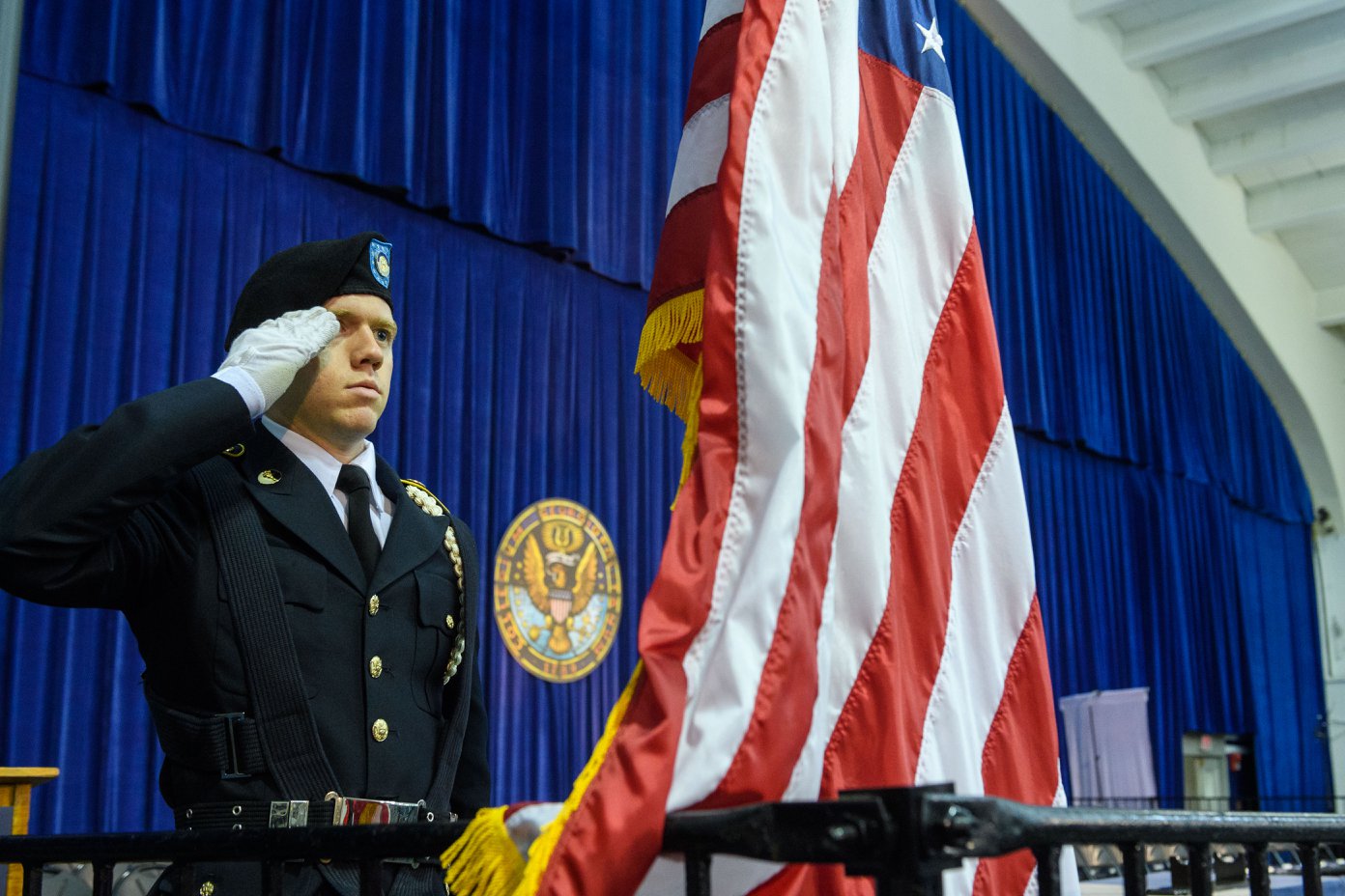 A soldier salutes an american flag.