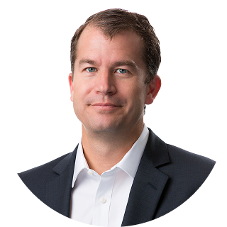 A man in a dark suit jacket and white shirt poses for a professional headshot against a plain white background.