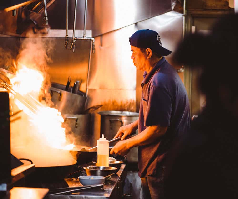 chef sautéing food in a saucepan